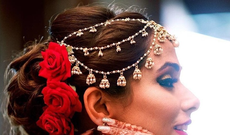 Photo of Bride looking out of window wearing mathapatti