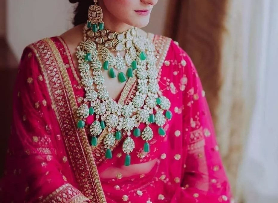 Photo of Conventional red bride wearing green jewellery